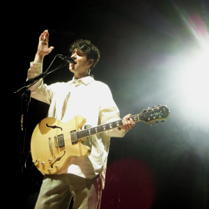Ezra Koenig close-up as he plays guitar